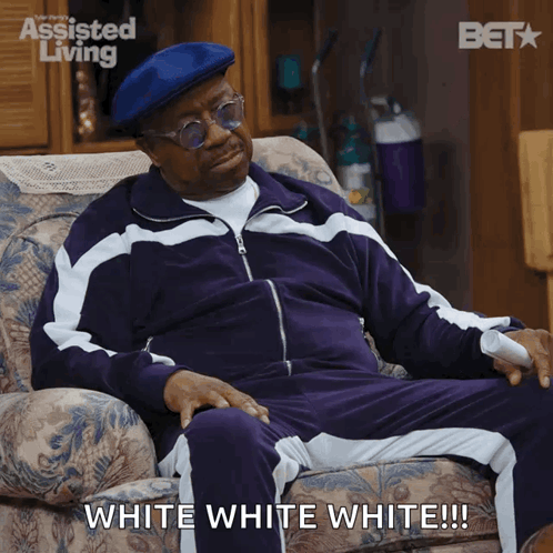 Man In Purple Tracksuit Sitting With White White White Caption GIF