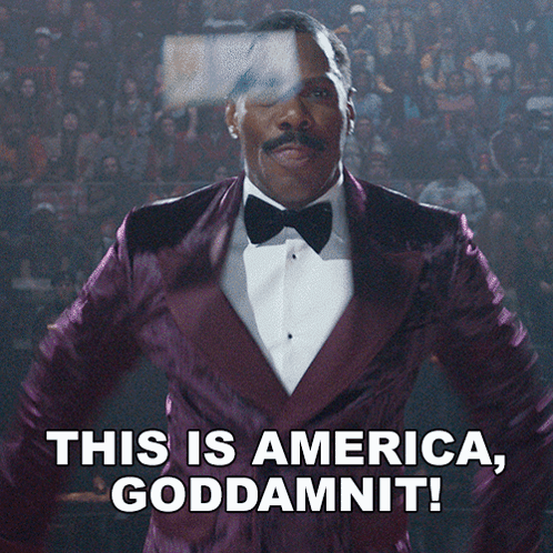 A Man In A Purple Tuxedo And Bow Tie Says This Is America Goddamnit GIF