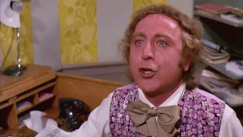 A Man In A Purple Vest And Bow Tie Is Making A Funny Face . GIF