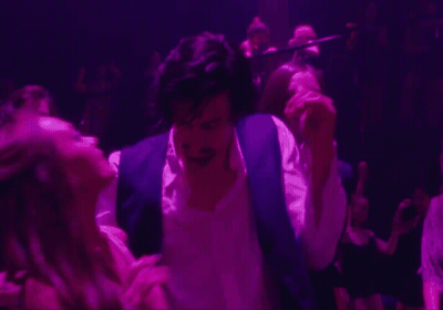 A Man In A Purple Vest Is Dancing With A Woman In A Pink Dress GIF