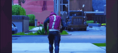 A Man In A Purple Vest Is Walking Down The Street In Front Of A Truck . GIF