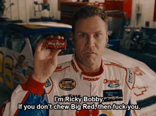 A Man In A Race Car Uniform Holds A Big Red Chewing Gum GIF