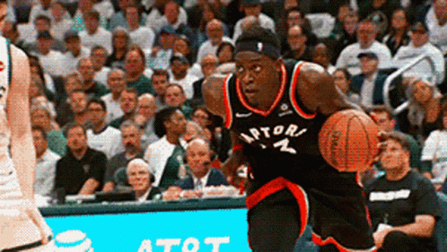 A Man In A Raptors Jersey Dribbles A Basketball In Front Of A Crowd GIF