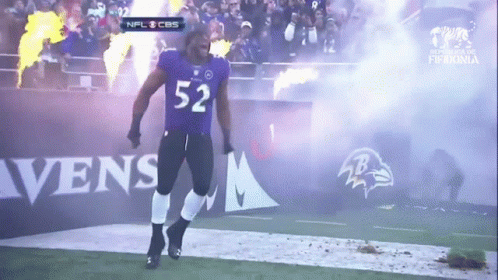 A Man In A Ravens Uniform Is Walking On The Field GIF