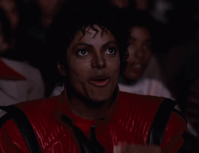 A Man In A Red And Black Jacket Is Eating Popcorn GIF