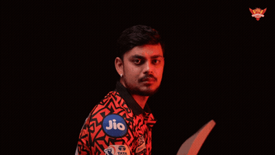 A Man In A Red And Black Shirt Is Holding A Piece Of Paper In His Hand GIF