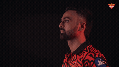 A Man In A Red And Black Shirt With Jio Written On His Sleeve GIF