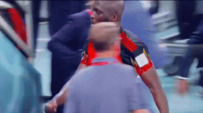 A Man In A Red And Black Shirt With The Letter A On It Is Standing Next To Another Man GIF