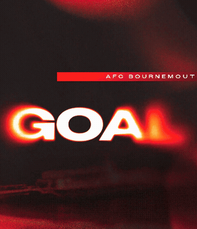 A Man In A Red And Black Striped Shirt Is Giving A Goal Sign GIF