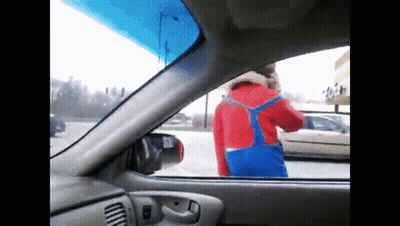 A Man In A Red And Blue Outfit Is Standing In A Parking Lot GIF
