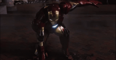 A Man In A Red And Gold Iron Man Suit Is Standing In Front Of A Building GIF