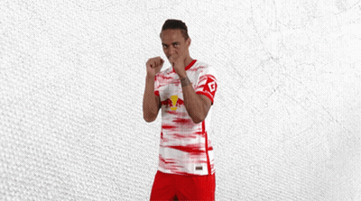 A Man In A Red And White Jersey With A Red Bull On The Front GIF