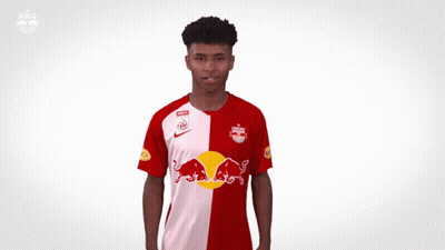 A Man In A Red And White Redbull Jersey GIF