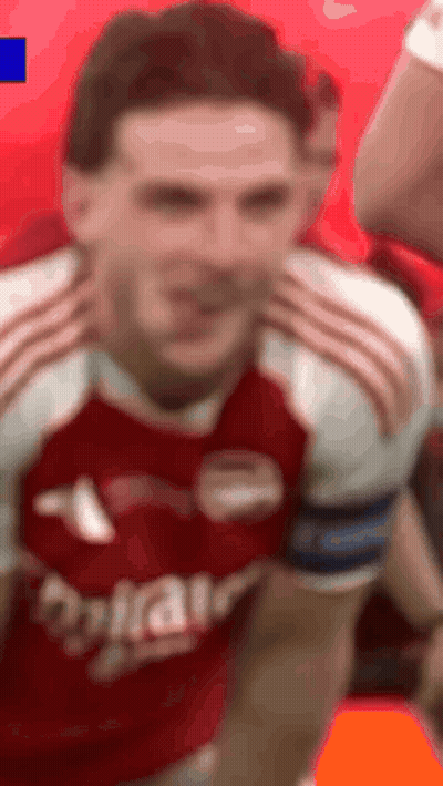 A Man In A Red And White Soccer Jersey Is Making A Face . GIF