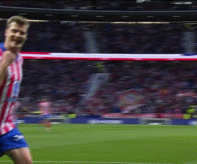 A Man In A Red And White Striped Shirt And Blue Shorts Is Playing Soccer On A Field . GIF
