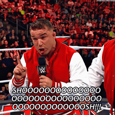 A Man In A Red And White Varsity Jacket Is Holding A Microphone And Says Shoo GIF