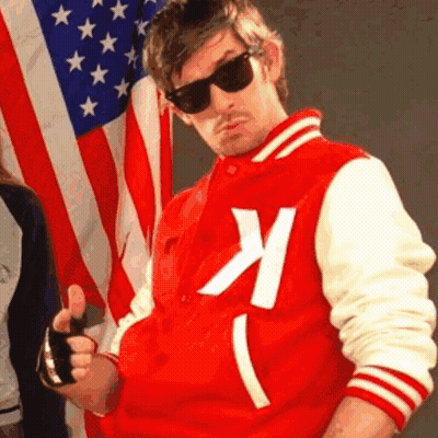 A Man In A Red And White Varsity Jacket With The Letter K On It GIF