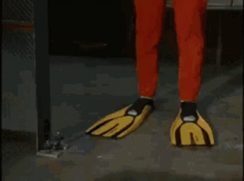 A Man In A Red And Yellow Superhero Costume Is Standing In A Hallway . GIF