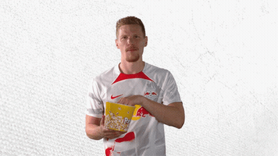 A Man In A Red Bull Shirt Holds A Bowl Of Popcorn GIF