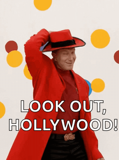 A Man In A Red Coat And Hat Is Saying " Look Out Hollywood " GIF