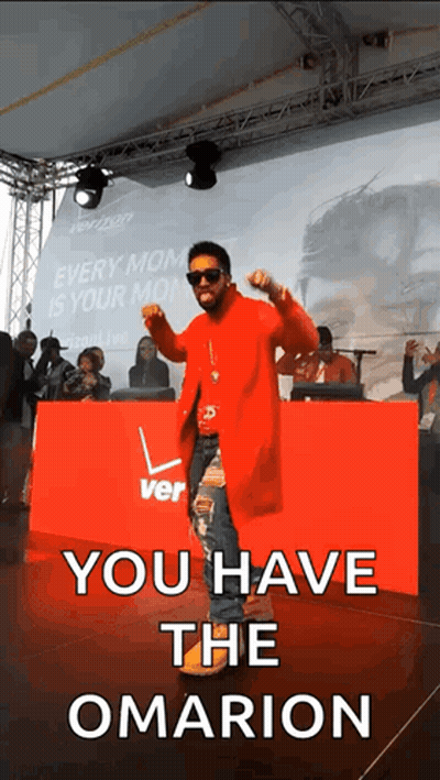 A Man In A Red Coat Is Dancing In Front Of A Sign That Says You Have The Omarion GIF