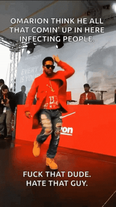 A Man In A Red Coat Is Dancing In Front Of A Verizon Sign GIF