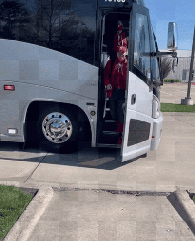 A Man In A Red Hat Is Getting Off A Bus That Says ' To You ' On The Side GIF
