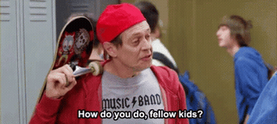 A Man In A Red Hat Is Holding A Skateboard And Talking To A Group Of Kids . GIF