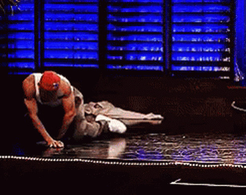 A Man In A Red Hat Is Kneeling Down On The Floor GIF