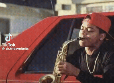 A Man In A Red Hat Is Playing A Saxophone In A Red Car .. GIF