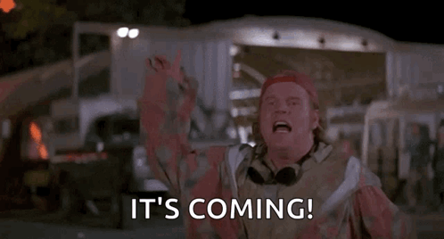 A Man In A Red Hat Is Saying `` It 'S Coming '' With His Arms In The Air . GIF
