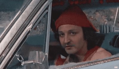 A Man In A Red Hat Is Sitting In A Car . GIF