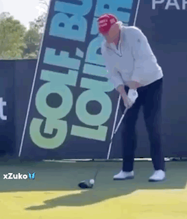 A Man In A Red Hat Is Swinging A Golf Club On A Golf Course . GIF