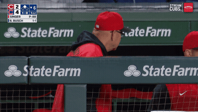 A Man In A Red Hat Sits In A Dugout With State Farm Advertisements GIF