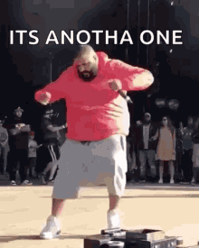 A Man In A Red Hoodie Is Dancing In Front Of A Crowd With The Words `` Its Anotha One '' . GIF