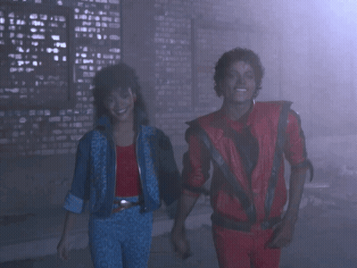 A Man In A Red Jacket And A Woman In A Blue Jacket Are Dancing GIF