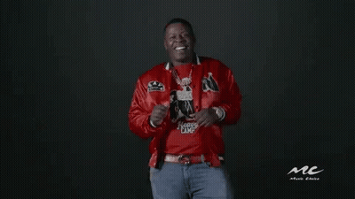 A Man In A Red Jacket And Blue Jeans Is Dancing . GIF