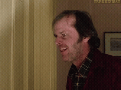 A Man In A Red Jacket And Plaid Shirt Is Standing In A Doorway And Smiling . GIF