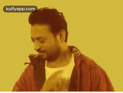 A Man In A Red Jacket And White Shirt Is Smoking A Cigarette On A Yellow Background . GIF