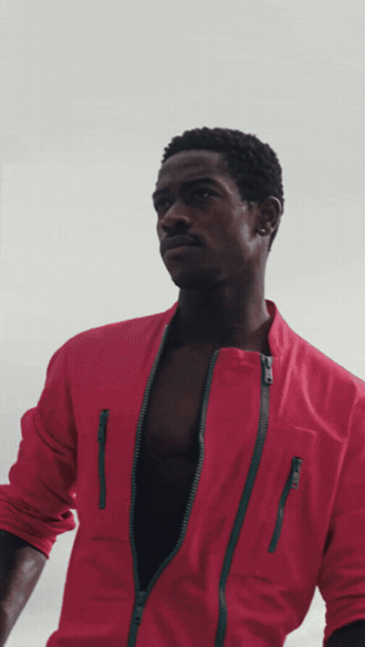 A Man In A Red Jacket Has A Green Zipper GIF