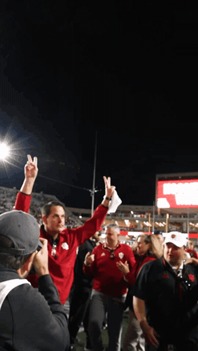 A Man In A Red Jacket Holds Up His Index Finger In The Air GIF