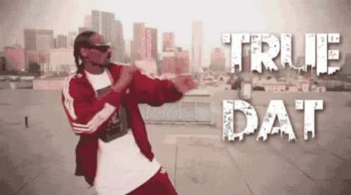 A Man In A Red Jacket Is Dancing In Front Of A City Skyline With The Words True Dat Above Him GIF