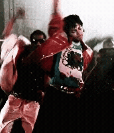 A Man In A Red Jacket Is Dancing With A Group Of People In A Room . GIF
