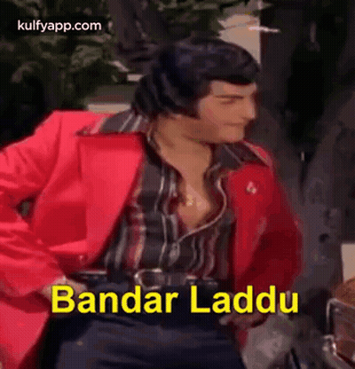A Man In A Red Jacket Is Dancing With The Words Bandar Laddu Written In Yellow . GIF