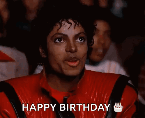 A Man In A Red Jacket Is Eating A Piece Of Food And Says Happy Birthday GIF