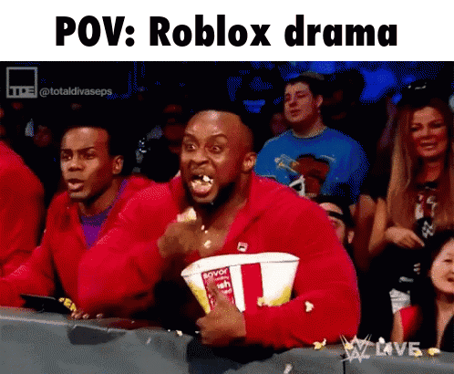 A Man In A Red Jacket Is Holding A Bucket Of Popcorn And Eating It GIF