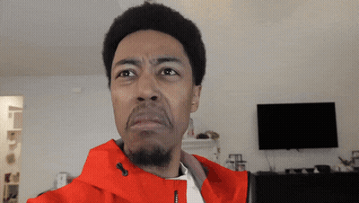 A Man In A Red Jacket Is Making A Face GIF
