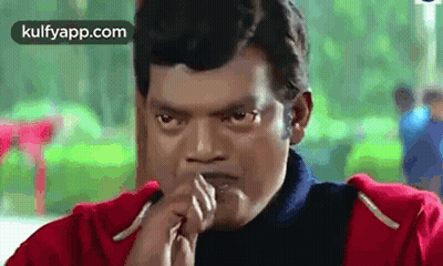 A Man In A Red Jacket Is Making A Funny Face With His Hands To His Mouth . GIF