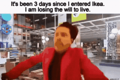 A Man In A Red Jacket Is Standing In An Ikea Store And Losing The Will To Live . GIF