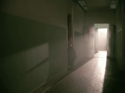 A Man In A Red Jacket Is Standing In Front Of A Door GIF